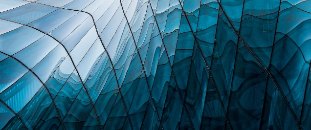 |Reflection of blue sky on building glass windows with curve lines.