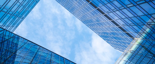 modern building with modern architecture where a lot of glass is used and clean lines and where the sky reflects in the windows.