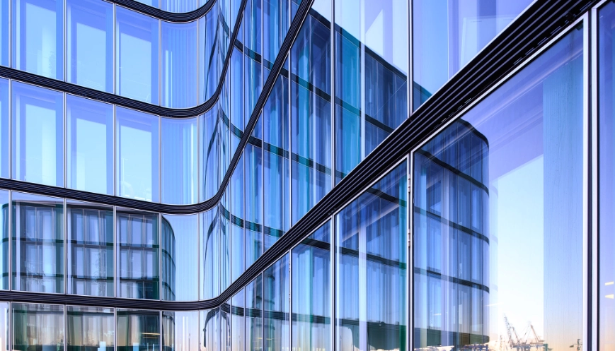 Reflection of the Hamburg harbor i a glass facade of a modern office building.|